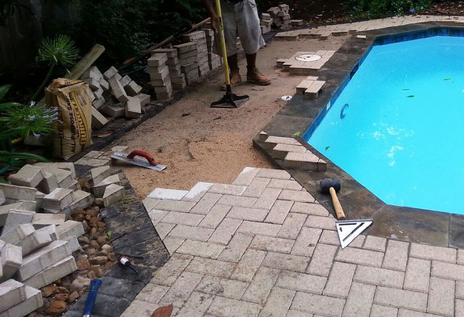  person working with pavers pool deck